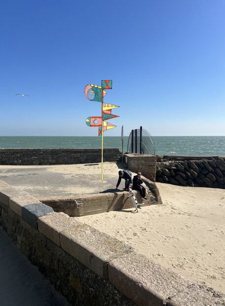 Eine Reihe von fahnenähnlichen Skulpturen weist mit Dankbarkeit und Verheißung auf das Meer.
